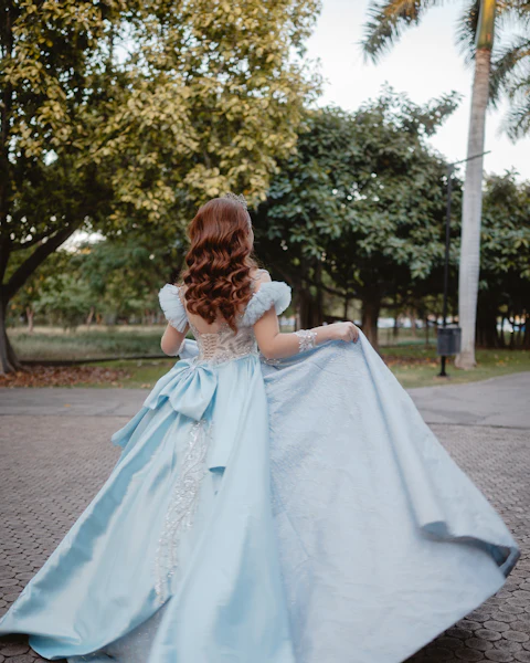 Woman twirling in a flowing light blue gown outdoors