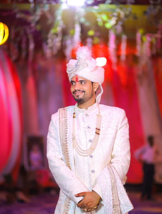 Groom in an ivory sherwani and safa with a pearl mala